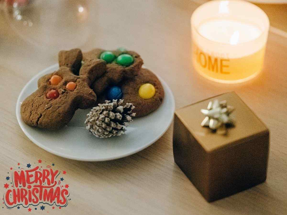 A plate of festive christmas cookies surrounded by candles, creating a warm and inviting holiday atmosphere.